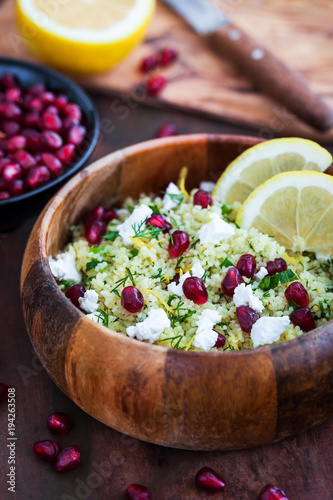 Delicious healthy cous cous salad with herbs, lemon zest, feta cheese and pomegranate seeds