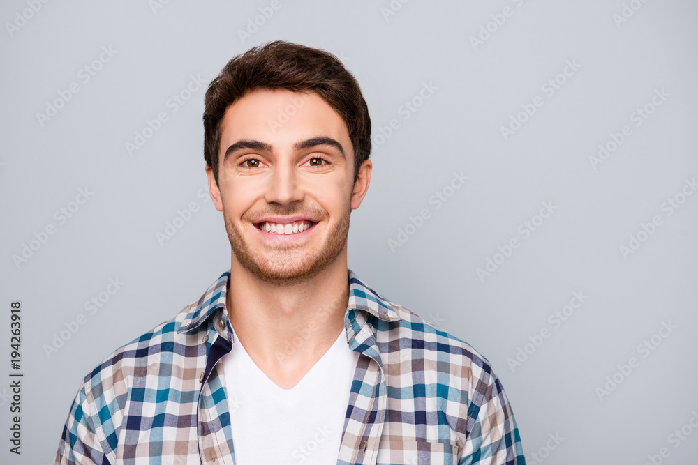 Portrait of positive, smiling, nice, kind gut in checkered shirt looking at camera isolated on grey background Portrait of positive, smiling, nice, kind gut in checkered shirt looking at camera isolated on grey background