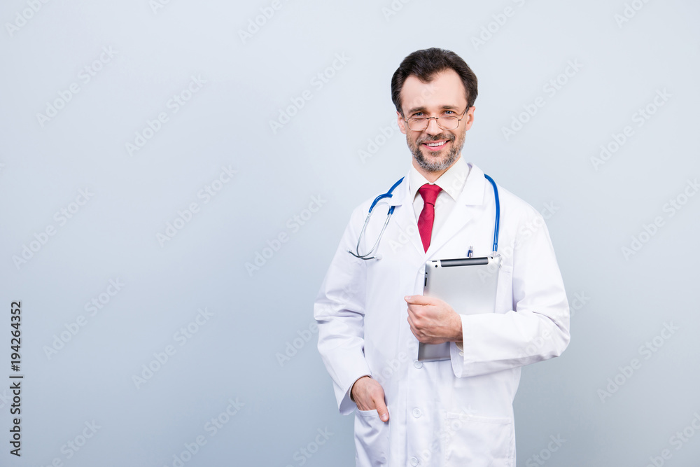 Portrait of specialist qualified experienced confident clever smart intelligent doctor wearing white formal-wear coat holding tablet ready for patients visiting isolated on gray background copyspace Portrait of specialist qualified experienced confident clever smart intelligent doctor wearing white formal-wear coat holding tablet ready for patients visiting isolated on gray background copyspace