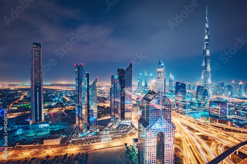 Spectacular nighttime skyline of a big modern city. Dubai, UAE. Aerial view on highways and skyscrapers.