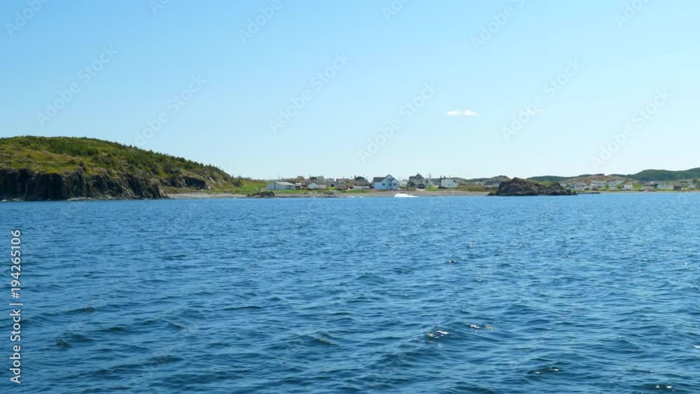 Slow motion small iceberg floats by town of twillingate Slow motion small iceberg floats by town of twillingate