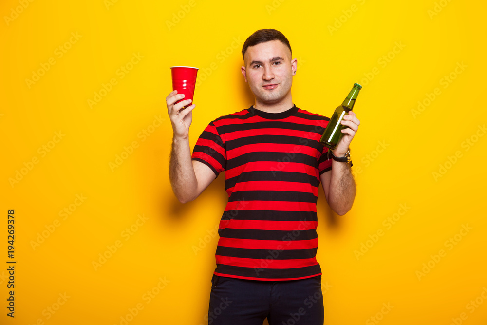Handsome man in bright T-shirt with beer Handsome man in bright T-shirt with beer