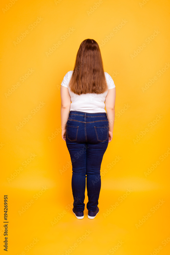 Fototapeta premium Rear view of young woman in tshirt and jeans