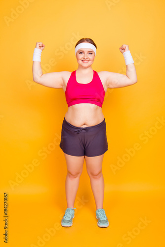 Young woman flexes biceps