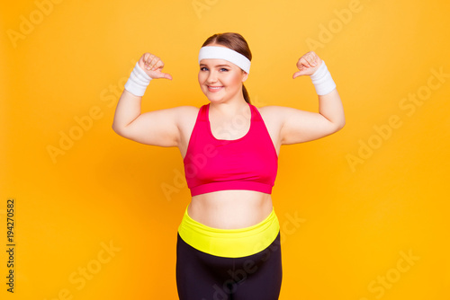 Young woman in exercise clothes flexes arms