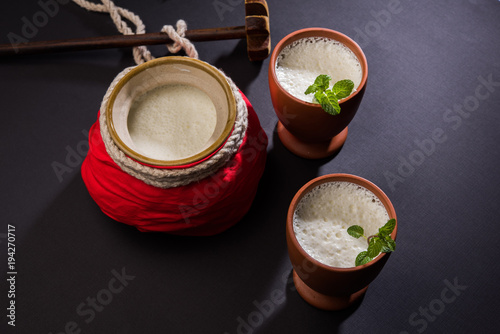 Lassie or lassi in terracotta glass - Lassi is an Authentic Indian cold drink made up of curd and milk and sugar, selective focus

