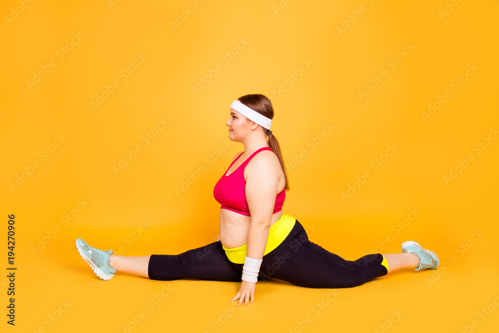 Young woman in exercise clothes does a forward split Young woman in exercise clothes does a forward split