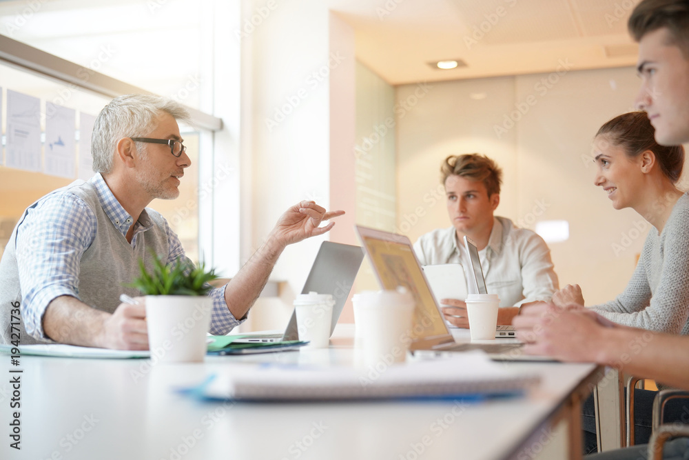 Teacher meeting around table with students Teacher meeting around table with students