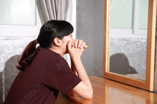 the woman sitting in front of mirror stand