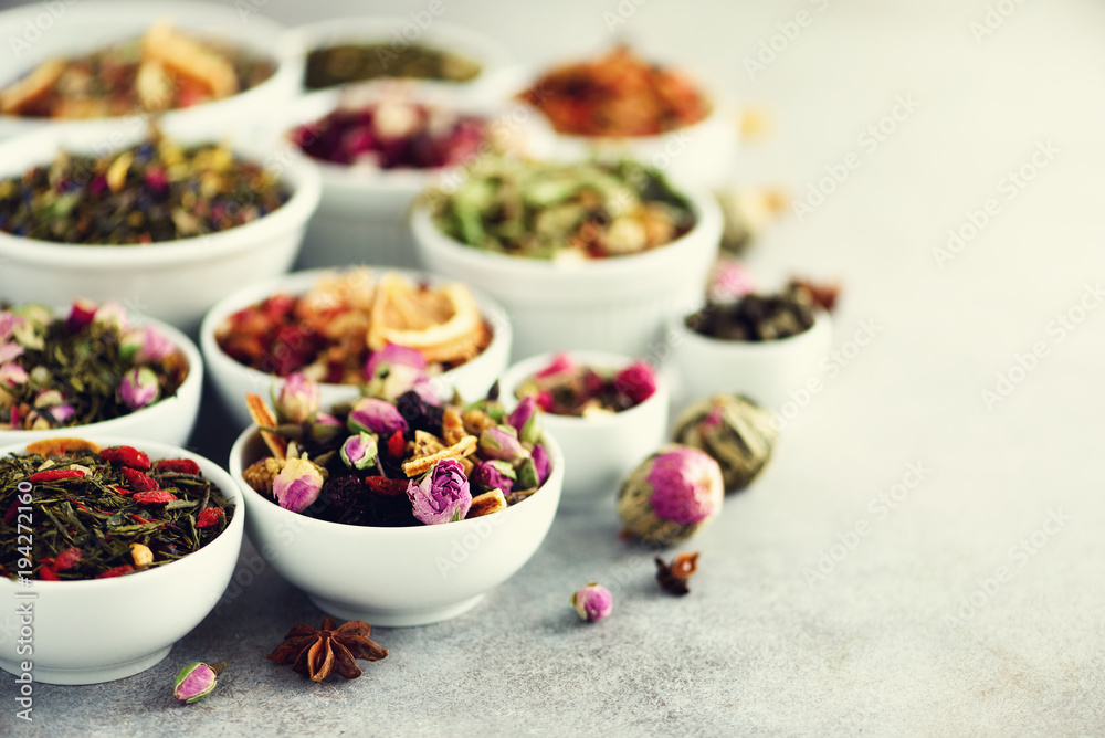 Assortment of dry tea in white bowls. Tea types backgound: green, black, floral, herbal, mint, melissa, ginger, apple, rose, lime tree, fruits, orange, hibiscus, raspberry, cornflower, cranberry Assortment of dry tea in white bowls. Tea types backgound: green, black, floral, herbal, mint, melissa, ginger, apple, rose, lime tree, fruits, orange, hibiscus, raspberry, cornflower, cranberry