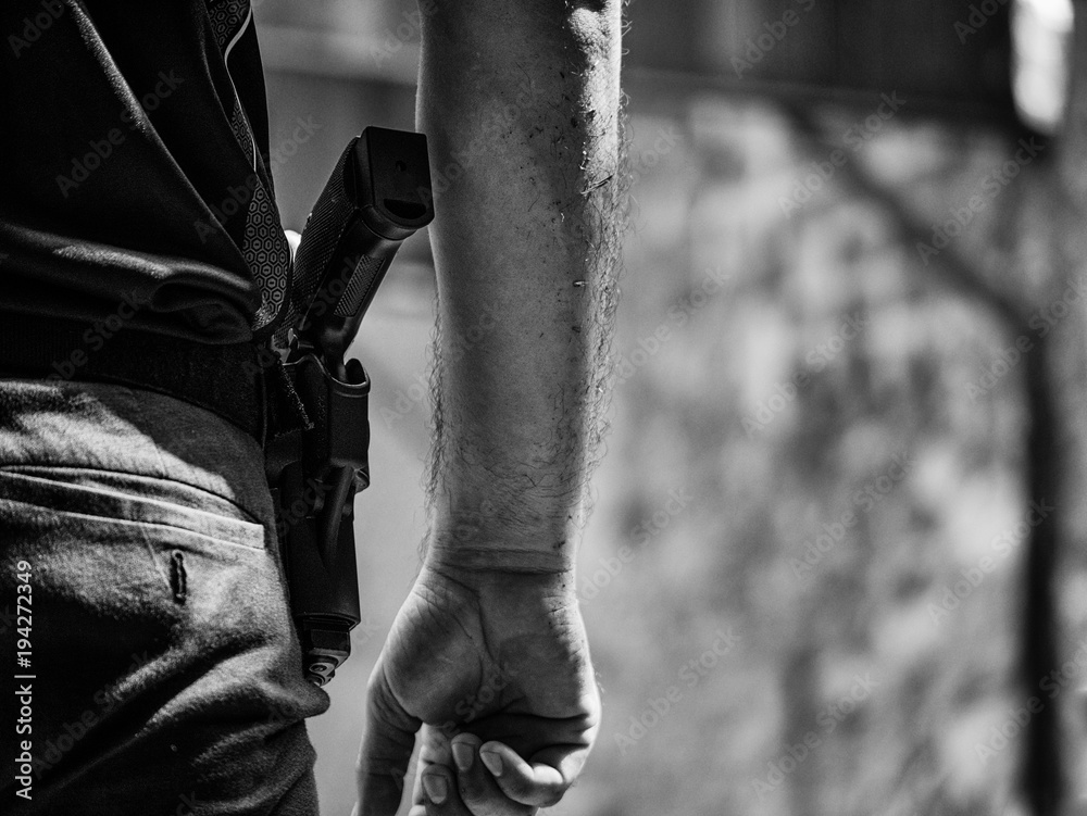 black and white image of male with handgun in holster standby for shooting competion black and white image of male with handgun in holster standby for shooting competion