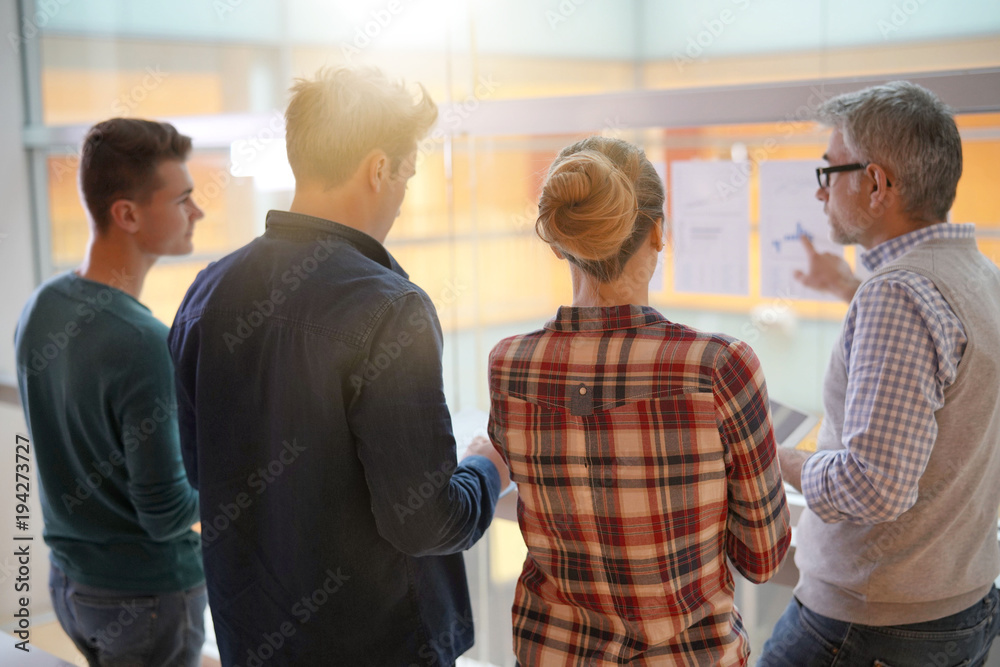 Fototapeta premium Group of students listening to business teacher