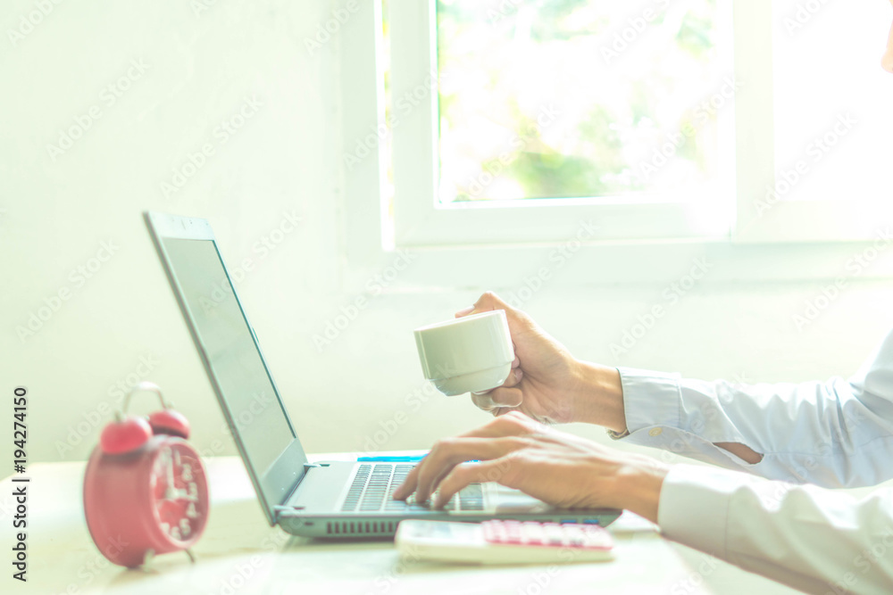 Fototapeta premium A business analyzing investment charts at workplace and using laptop and touch calculator.