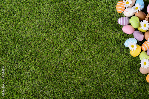 Photography above top view of multi colored painted easter eggs on green grass with springti