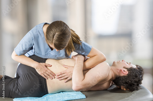Physiotherapist doing manipulation to man patient. Osteopathy