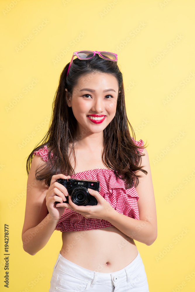 Fashion portrait of a young model with wet long hair holding camera.