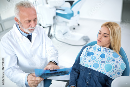 Dentist and patient looking at x-ray of teeth