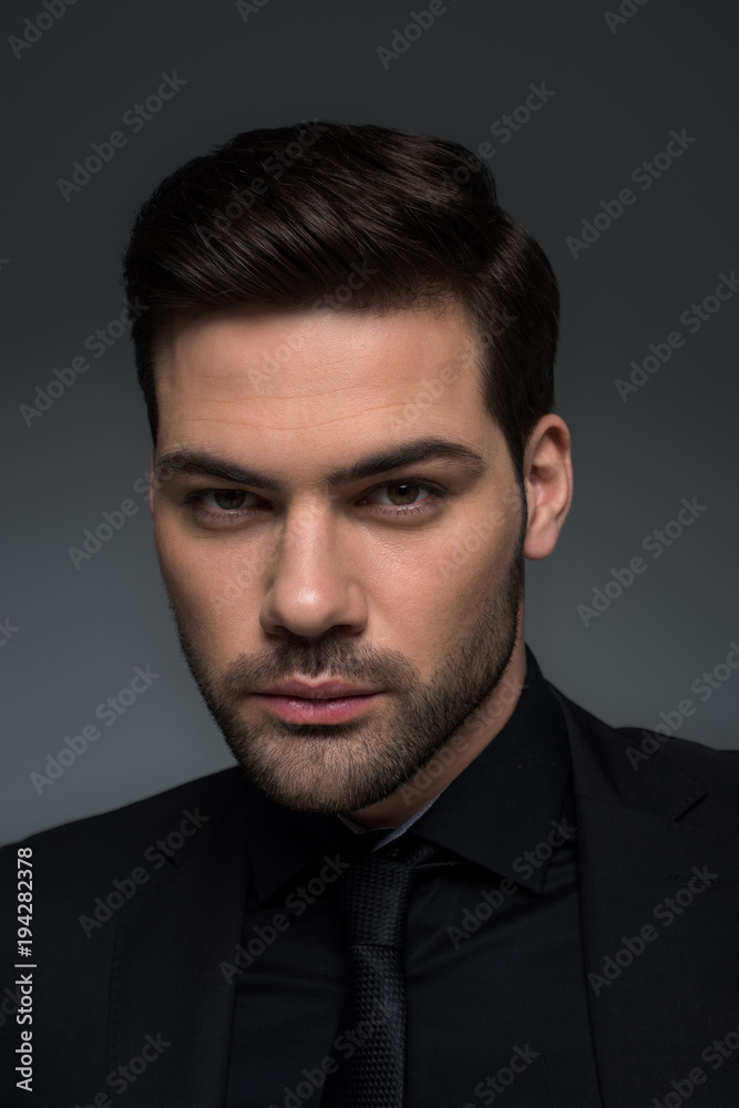 Headshot of stylish man in suit isolated on grey Headshot of stylish man in suit isolated on grey