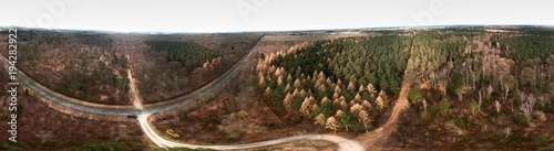 Composite panorama of aerial photographs and aerial photos of a forest area with spruce, pine and fir trees in the heath, abstract effect through a 360-degree photograph.