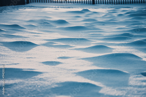 the blue evening snow curface like the sea waves with lights and shadows 