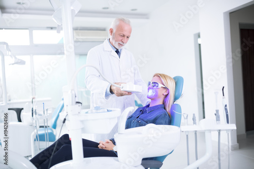 Dentist adjusts teeth whitening device
