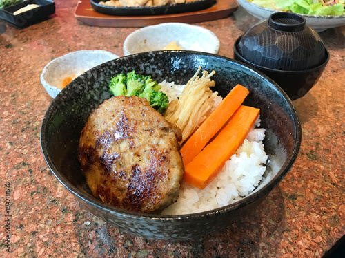 Japanese cuisine, rice topped with hamburg steak or Hambagu, made from ground beef or pork, carrot, broccoli and mushroom photo