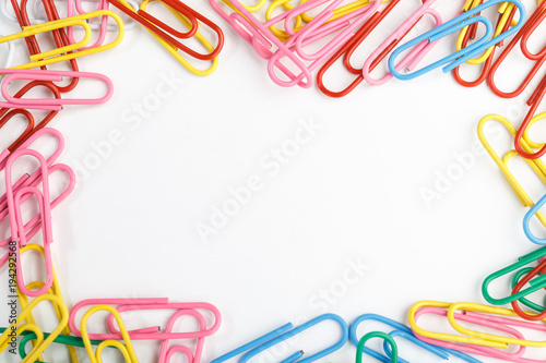 A lot of colorful paper clips on white background.