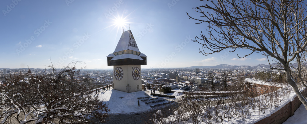panoramic view of clocktower uhrturm on schlossberg hill in winter, graz, austria