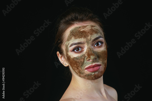 A young woman in a cosmetic mask on her face