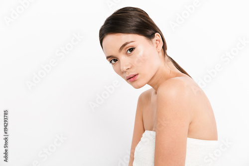 Young woman in towel looking camera isolated over white