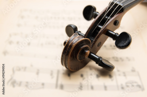 Old violin lying on the sheet of music, music concept