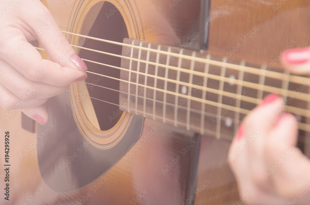 Fototapeta premium woman's hands playing acoustic guitar, close up