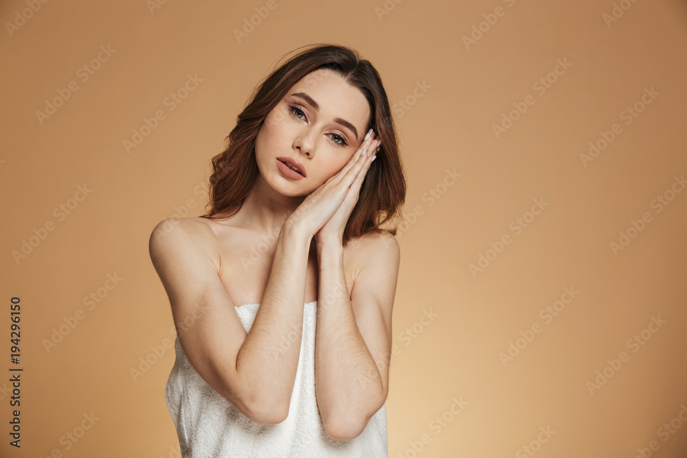 Young tired woman in towel showing sleeping gesture isolated Young tired woman in towel showing sleeping gesture isolated