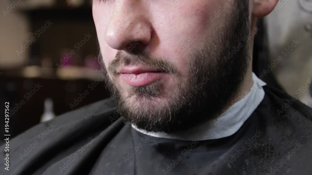 Barber cuts the hair of the client brunette man with barber tools. Barber cuts the hair of the client brunette man with barber tools.