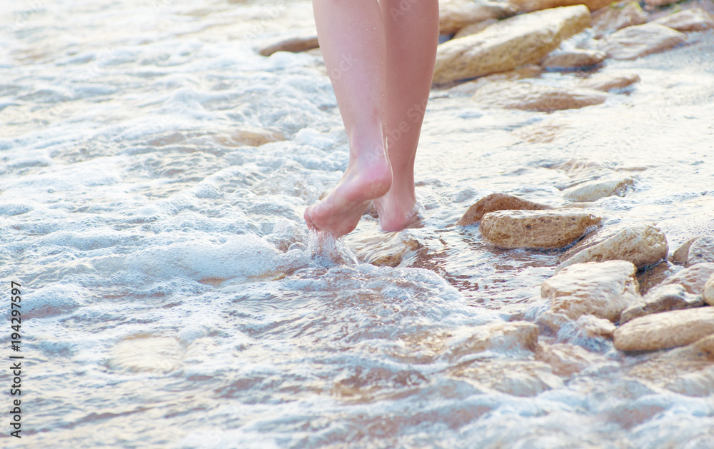 Woman's legs walking by sea shore. Woman's legs walking by sea shore.