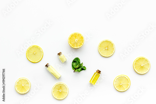 Natural organic cosmetics with lemon. Lemon oil or lotion, spa salt in small bottles on white background top view copy space
