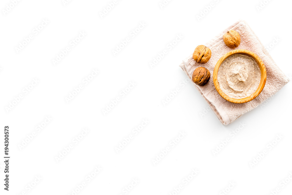 Natural cosmetics for skin care. Body scrub with walnut. White background top view copy space Natural cosmetics for skin care. Body scrub with walnut. White background top view copy space