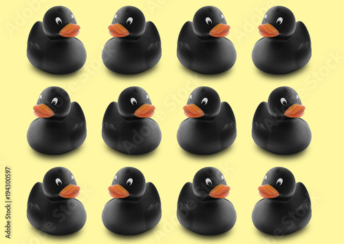 Obraz na plátně Seamless pattern of black rubber ducks in isolated yellow pastel background