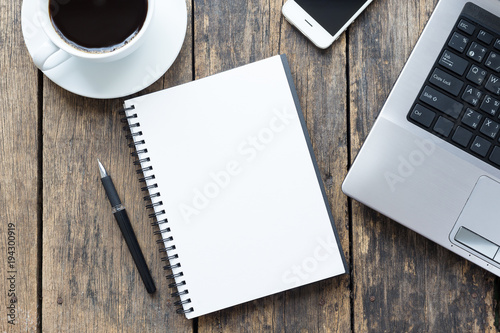 empty notebook with smart phone and computer on wooden table  top view