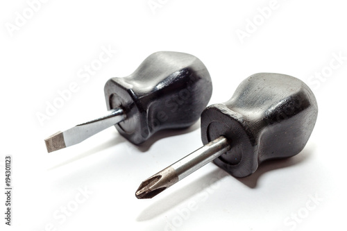 Stubby or small flat head screwdriver and cross head screwdriver, standard screwdriver and philips screwdriver with black handle  on white background.