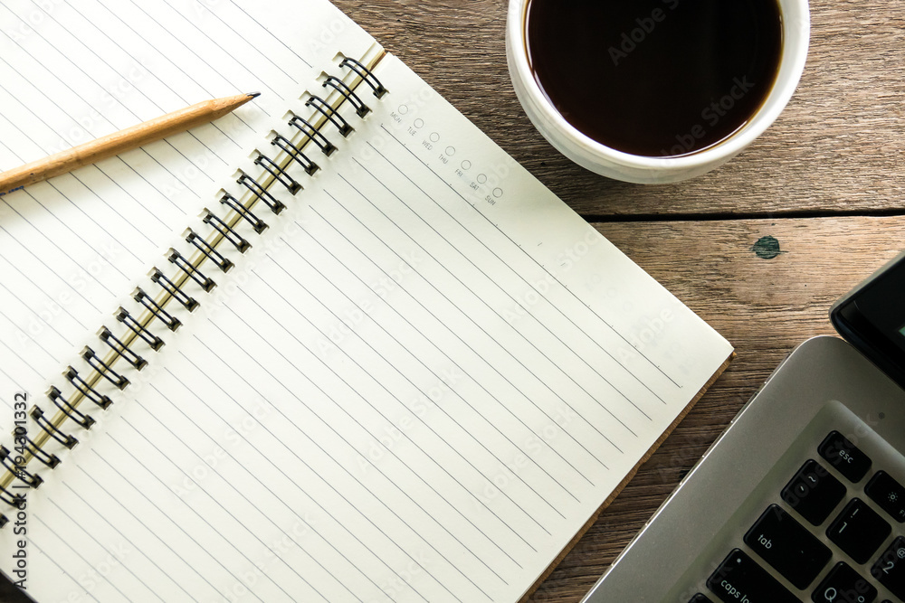 Top view of blank notebook with white coffee and natural light on wooden table. Top view of blank notebook with white coffee and natural light on wooden table.