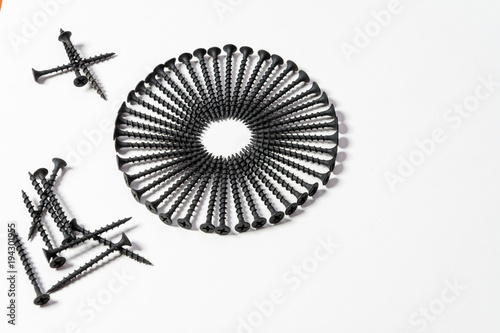 Wonderful circle of black screws  set one by one  isolated on a white background