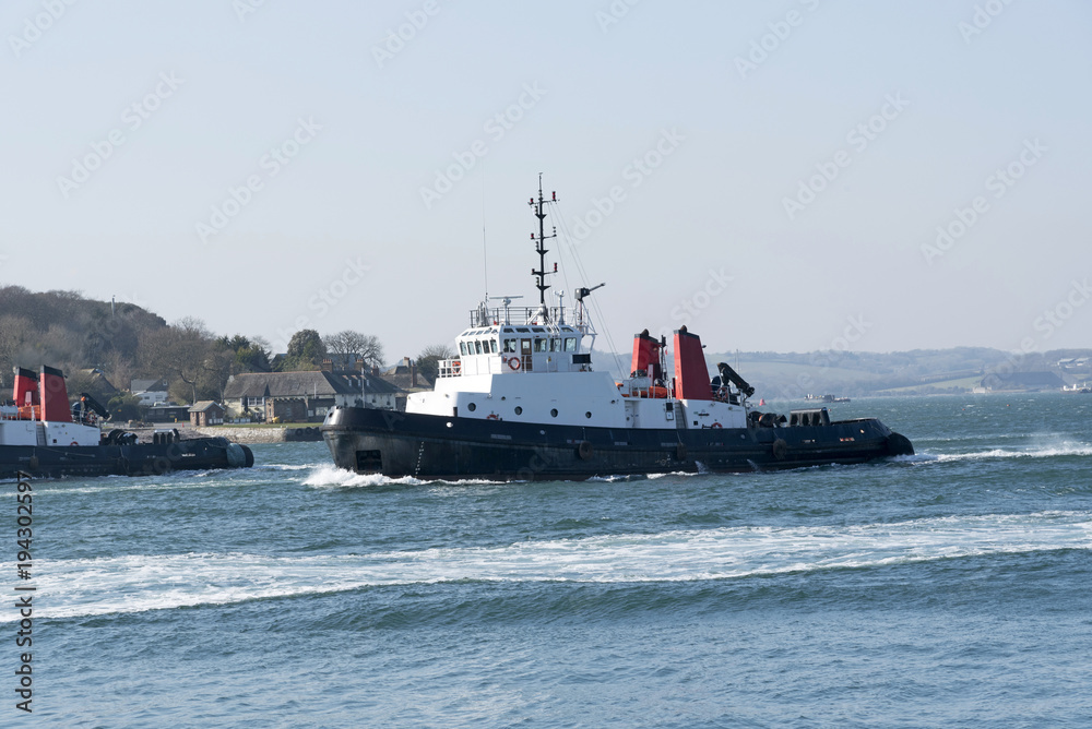 Obraz premium Plymouth, Devon, England, UK. Ocean going tug SD Adept underway departing Devonport Harbour. February 2018