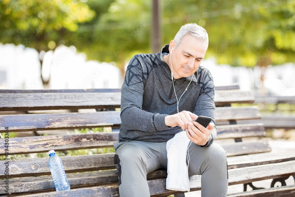Fototapeta premium Middle age man listening music after workout