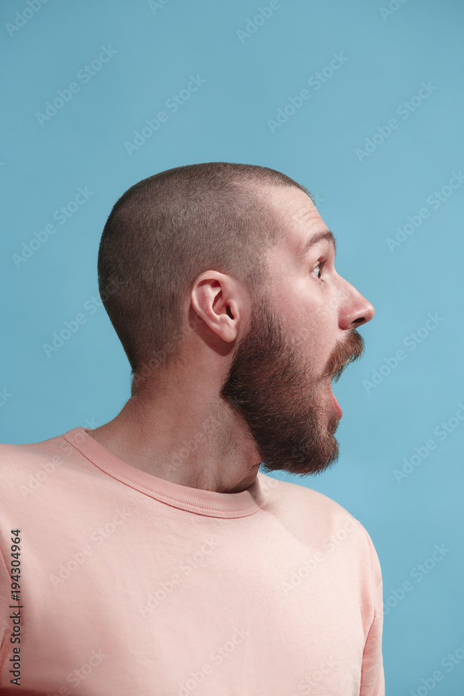The young attractive man looking suprised isolated on blue The young attractive man looking suprised isolated on blue