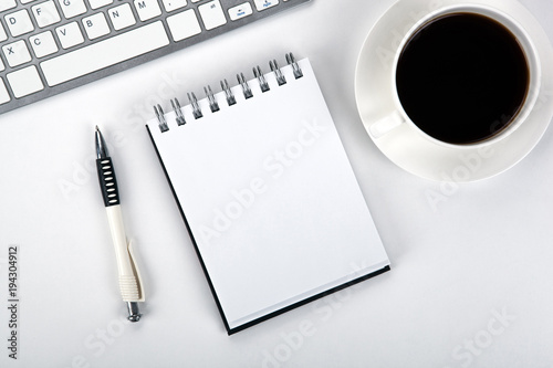 business still life of a notebook, coffee cup and keyboard on the desktop