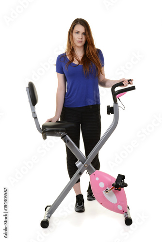 young woman standing by exercise bike