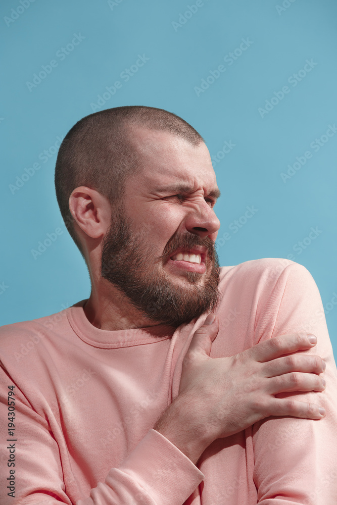 Young man overwhelmed with a pain in the shoulder. Young man overwhelmed with a pain in the shoulder.
