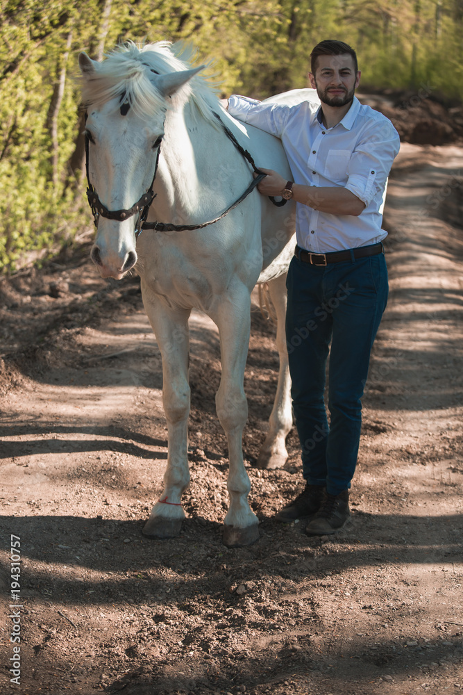 Young man with a horse. Autumn outdoors scene Young man with a horse. Autumn outdoors scene