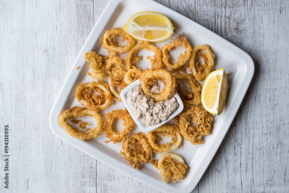 Fried Crispy Calamari Squid Rings with Tartar Sauce and Lemon.